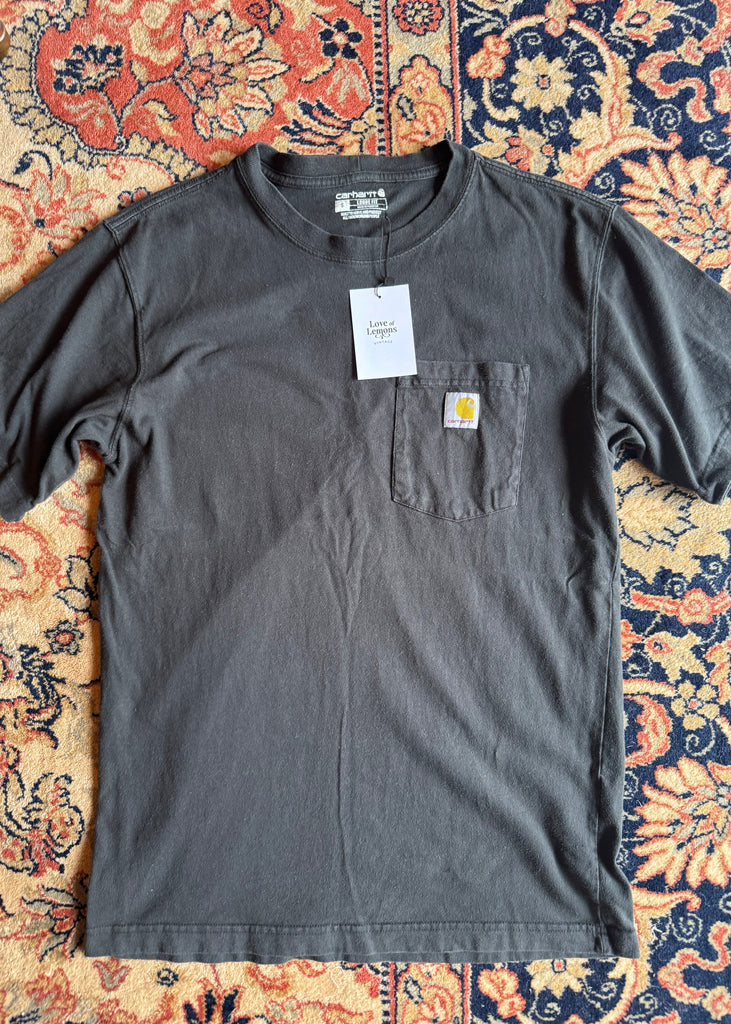 Gray t-shirt with a brand logo on a patterned fabric background