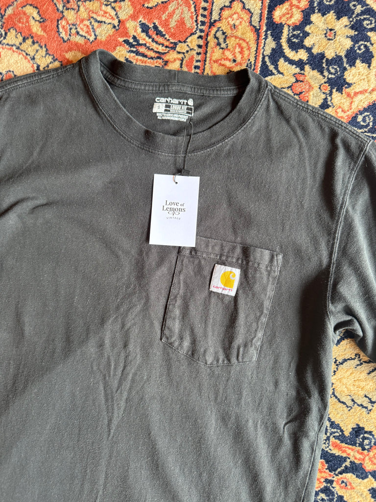 Gray t-shirt with a brand label on a patterned fabric background