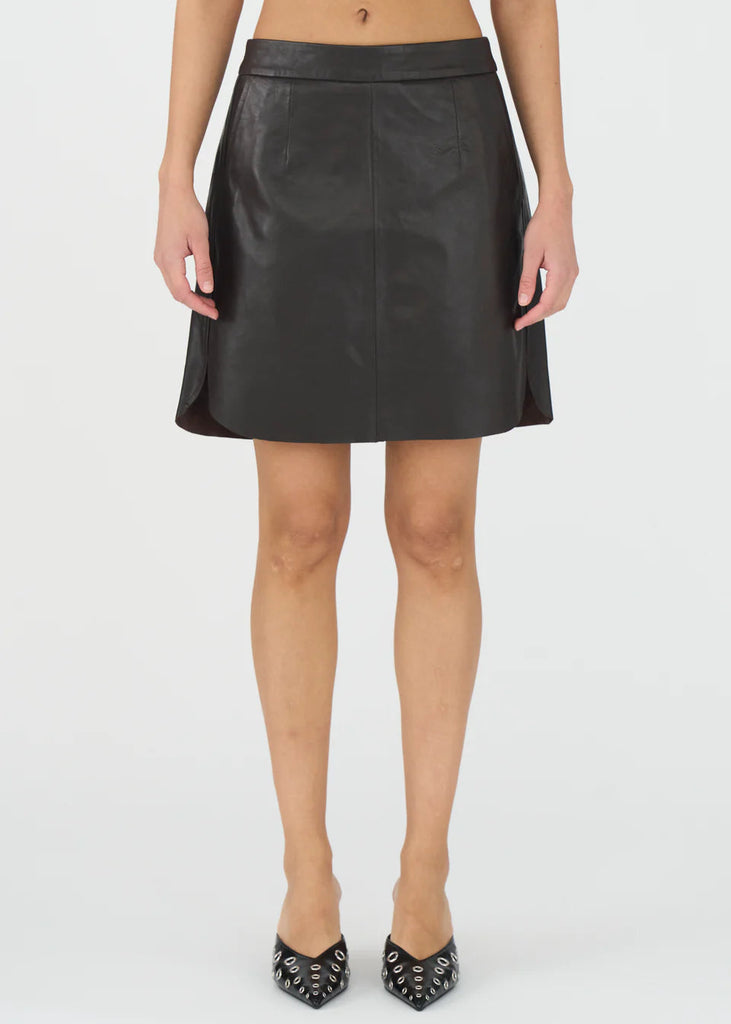 Person wearing a black leather skirt on a white background