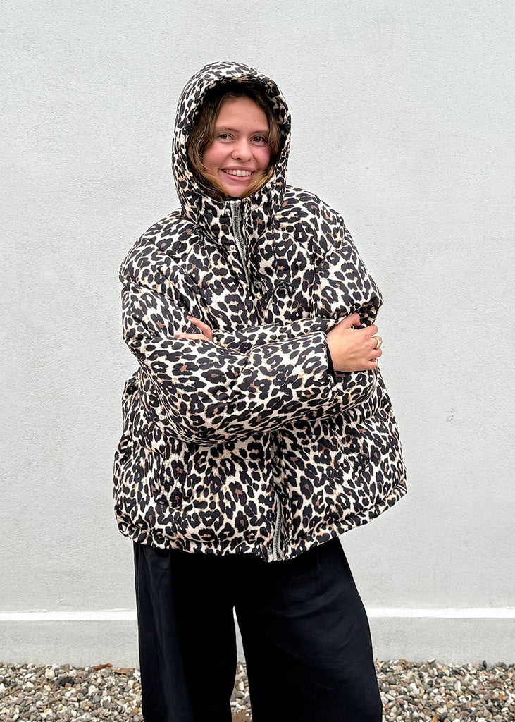 Person wearing a leopard print raincoat against a plain background
