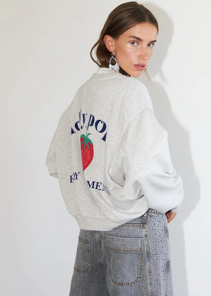 Person wearing a gray sweatshirt with branding on a white background