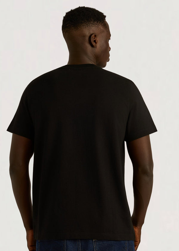 Person wearing a black t-shirt on a plain background