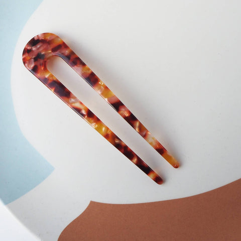 Tortoiseshell hair clip on a colorful abstract background