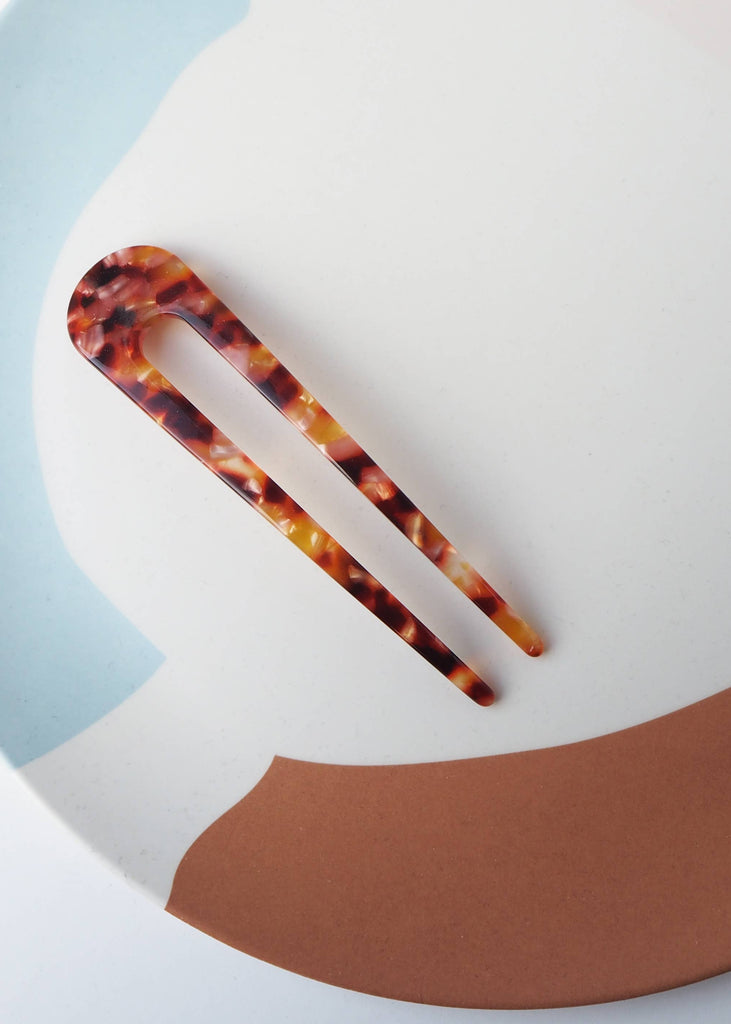 Tortoiseshell hair clip on a colorful abstract background