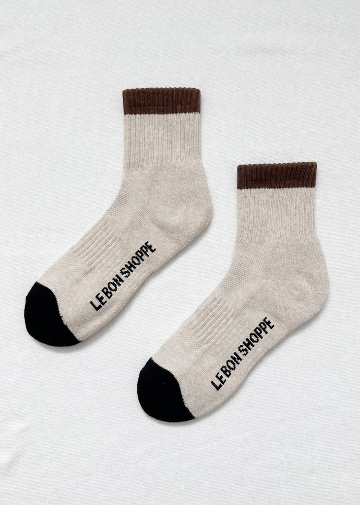 Pair of socks with brown cuffs and black toes on a white background