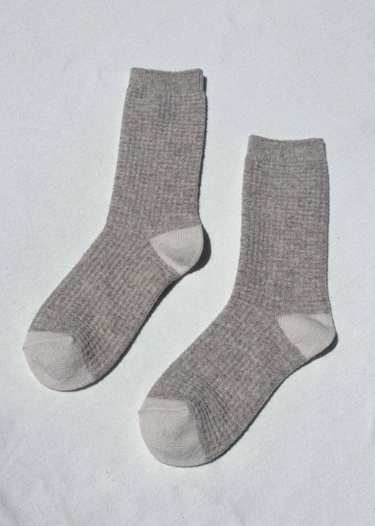 Pair of gray socks on a light gray background