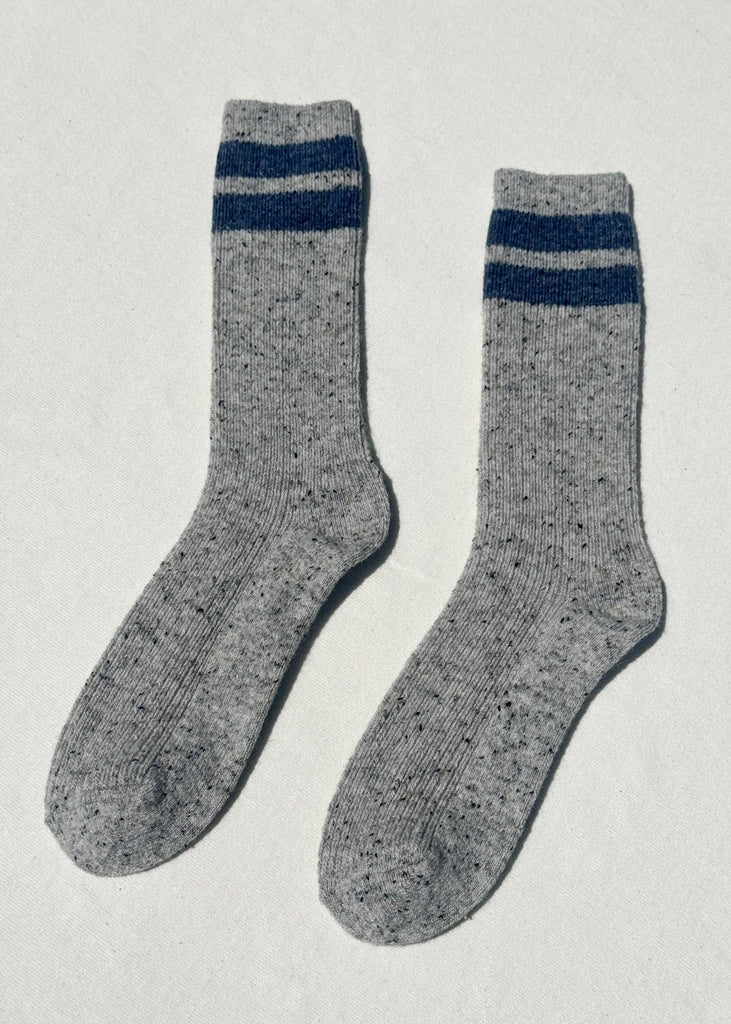 Pair of gray socks with blue stripes on a light gray background