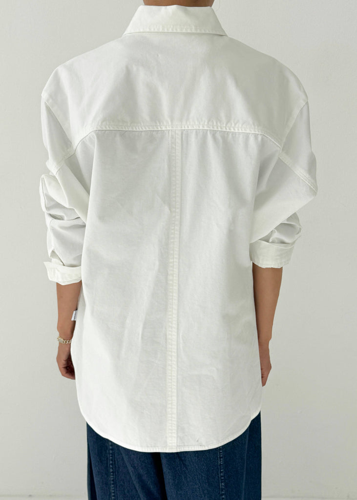 Person wearing a white shirt and blue pants against a white background