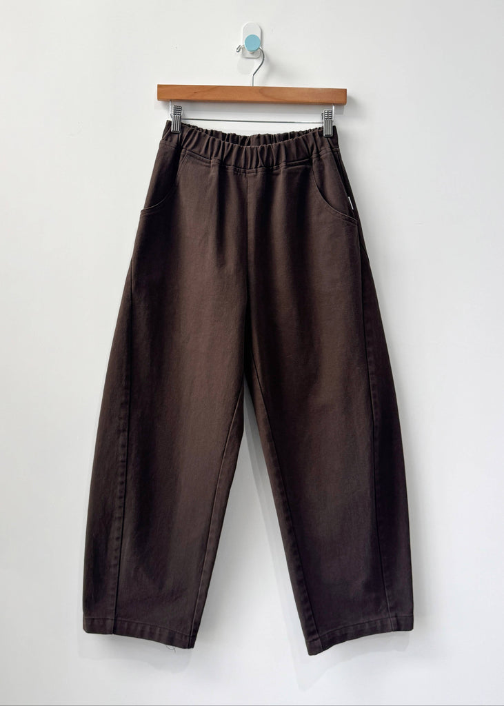 Brown pants on a hanger against a white background