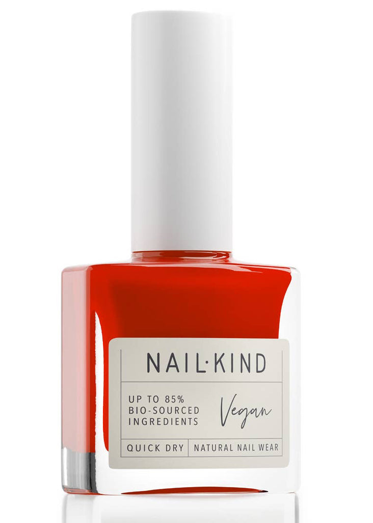 Red nail polish bottle with a white cap on a white background