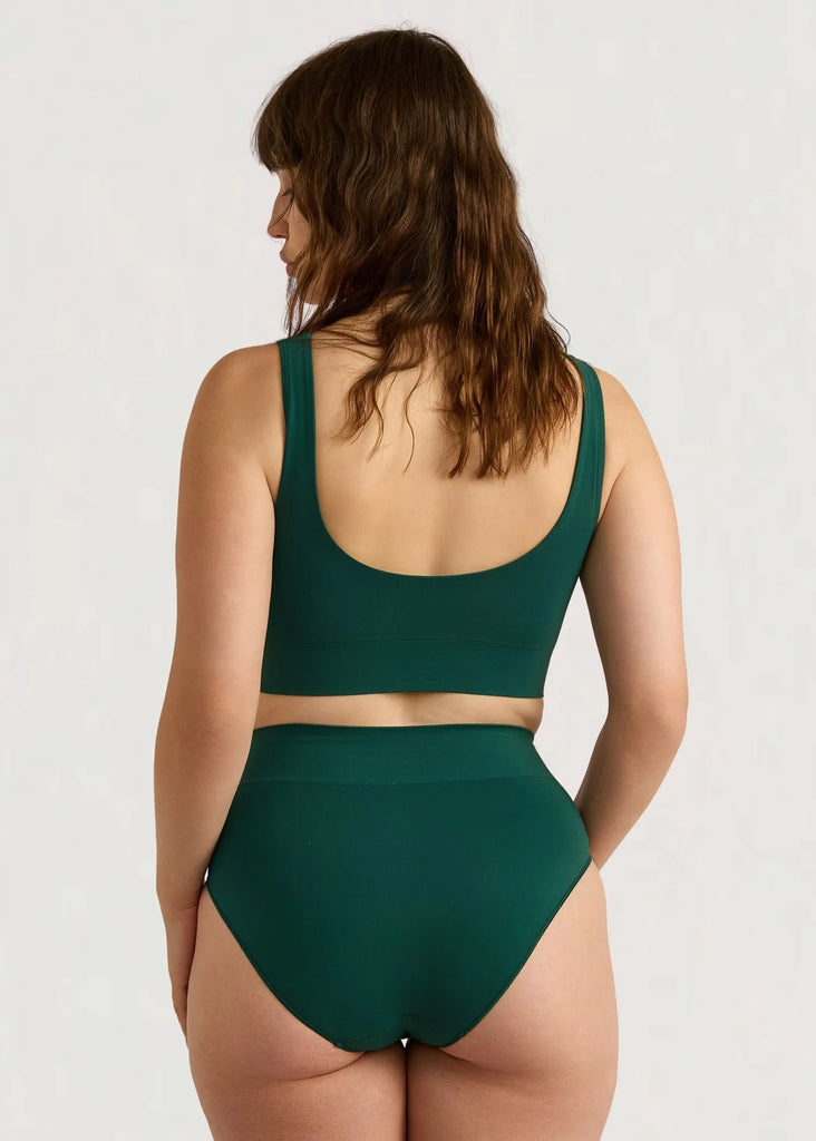 Woman wearing a green bikini set on a white background