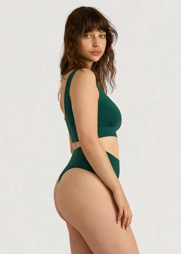 Woman wearing a green bikini set on a white background