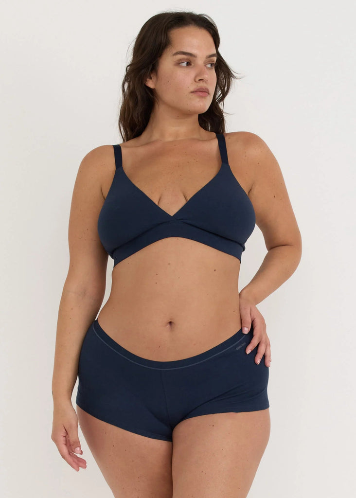 Woman wearing a navy blue bikini set on a white background