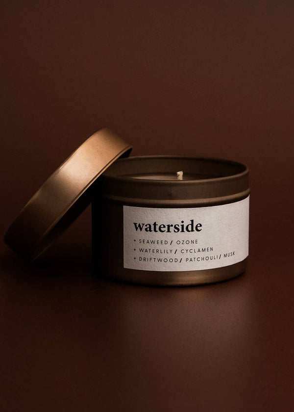Candle in a tin with 'waterside' label on a brown background