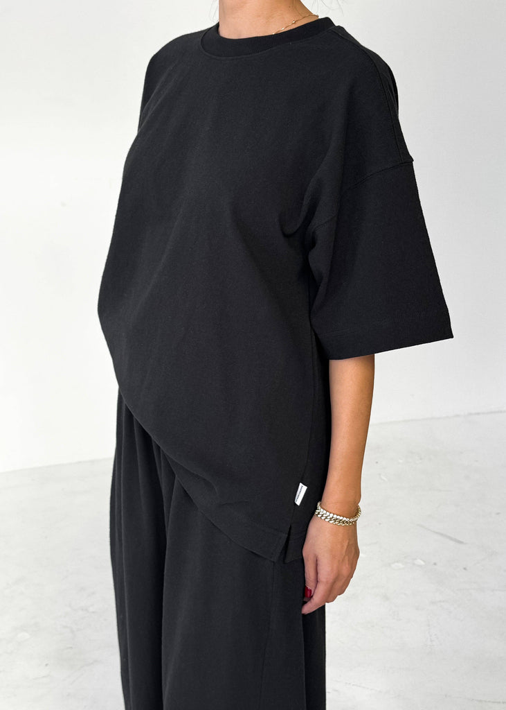 Person wearing a black outfit on a white background