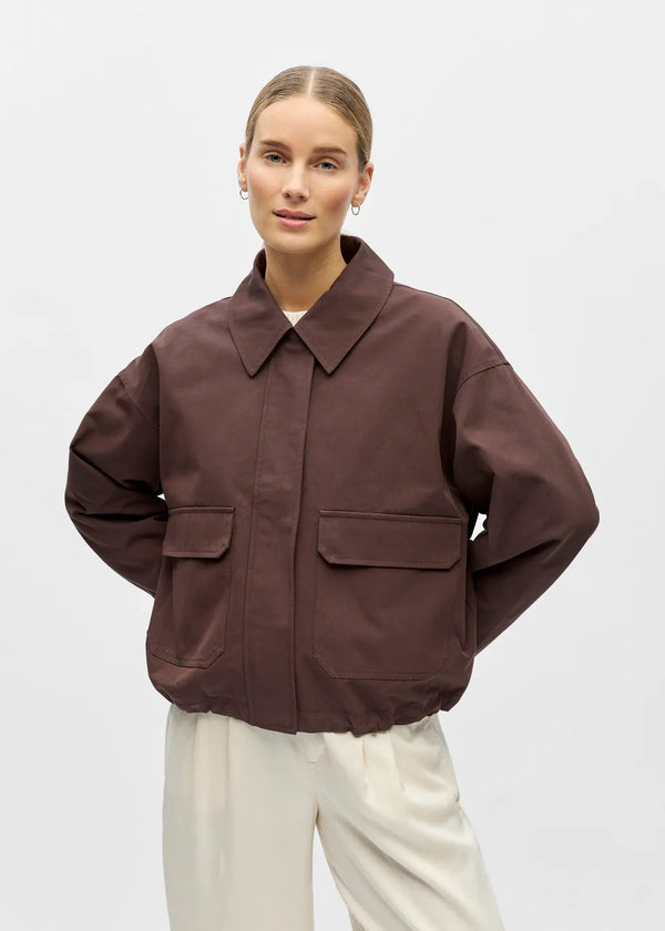 Person wearing a brown jacket on a white background