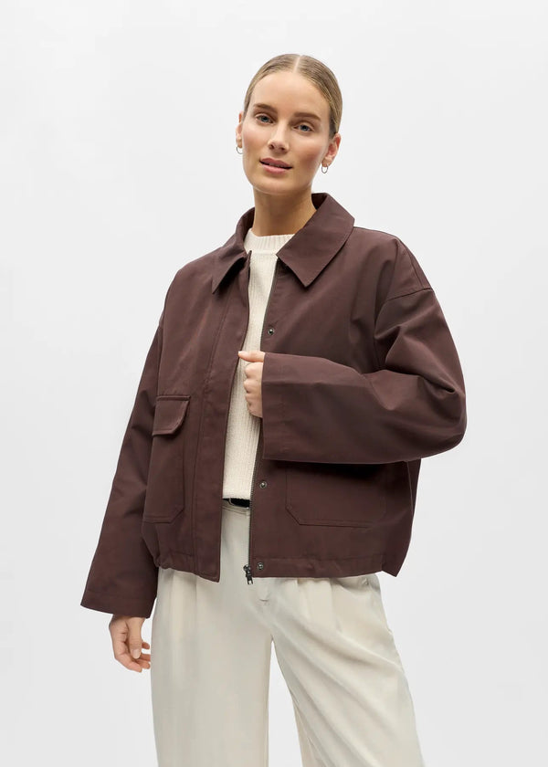 Person wearing a brown jacket on a white background