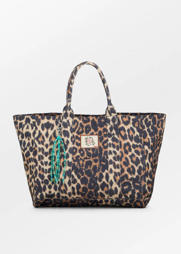 Leopard print tote bag with decorative element on a white background