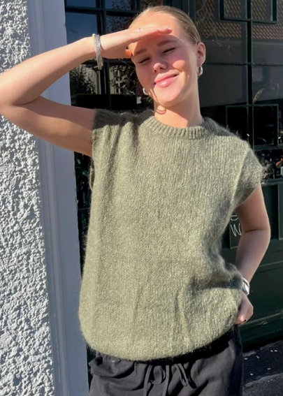 Person wearing a khaki vest with 'Ost London' branding on a smartphone screen.