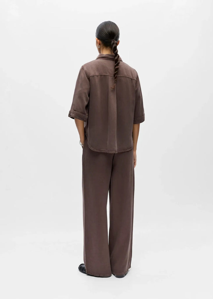 Person wearing a brown outfit on a white background