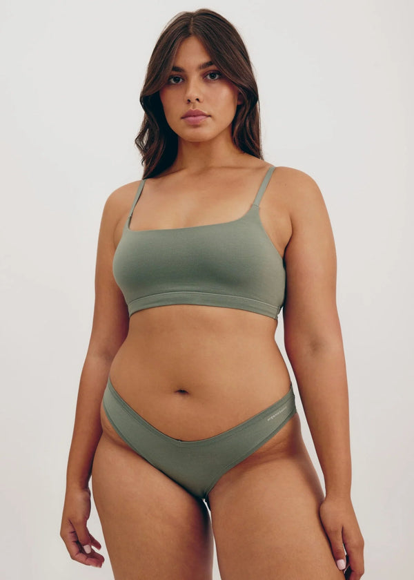Woman wearing a green bikini set against a plain background